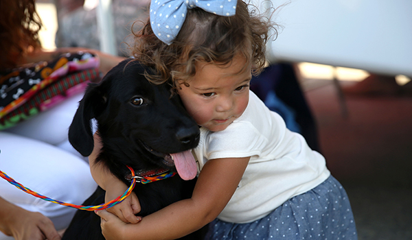 Aaliyah, 1, shares a special moment with her new furry family member at the Camp Pendleton Animal Shelter during the annual adoption event July 26. Teresa Setter, the shelter supervisor, said she hopes to see at least 22 dogs and cats find good homes because of this event.     In addition to pet adoptions, there were also veterinarians on sight to perform free microchiping and exams for the adopted animals, gift bags with pet items in them and pony rides. For more information on the animals in the shelter please visit building 25132 or call 760-725-8120.